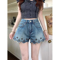 ZOFIA ATELIER blue denim shorts with floral embroidery and scalloped hem. Mid-rise waist.
