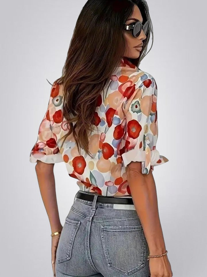 ZOFIA ATELIER floral long sleeve blouse with notched collar, featuring red, orange, and blue abstract floral print on a white background.