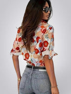 ZOFIA ATELIER floral long sleeve blouse with notched collar, featuring red, orange, and blue abstract floral print on a white background.