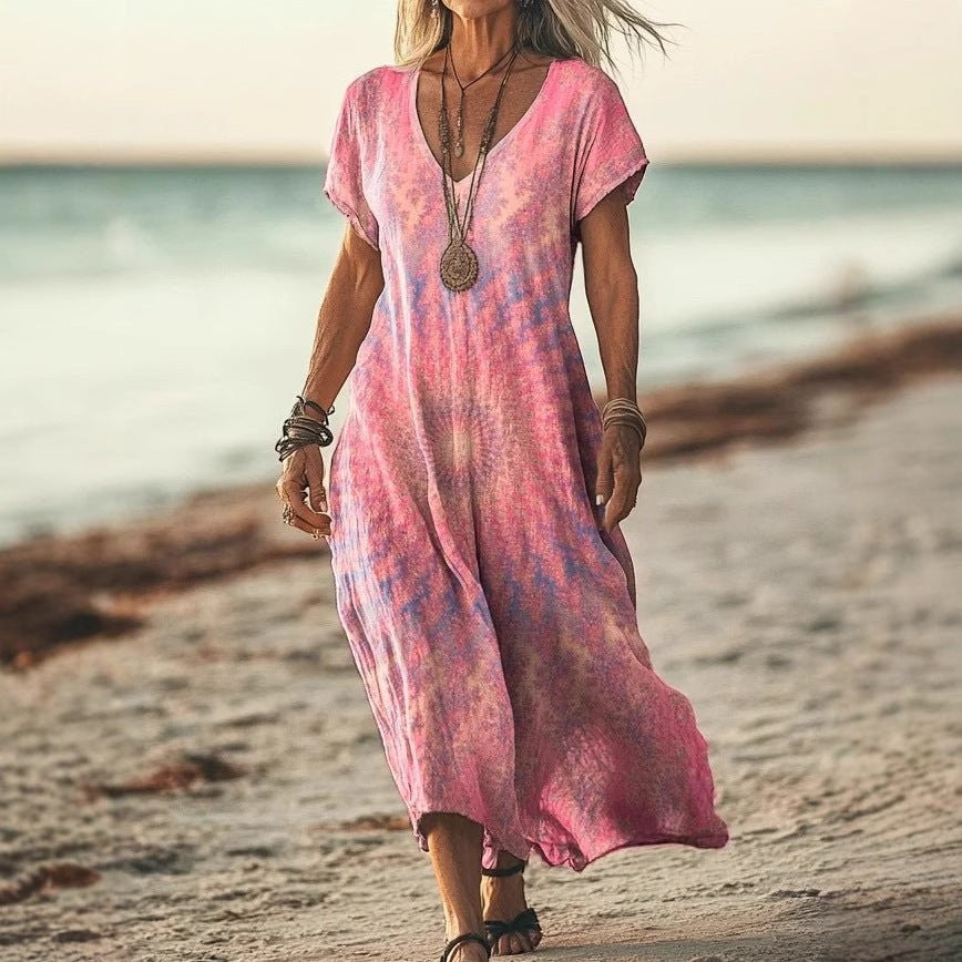 ZOFIA ATELIER GABRYSIA floral v-neck midi dress in pink and blue tie-dye, short sleeves, flowing silhouette, worn on a beach.