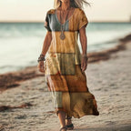 ZOFIA ATELIER Gabrysia floral V-neck midi dress in tan, brown, and blue patchwork print. Flowing, lightweight fabric with short sleeves.