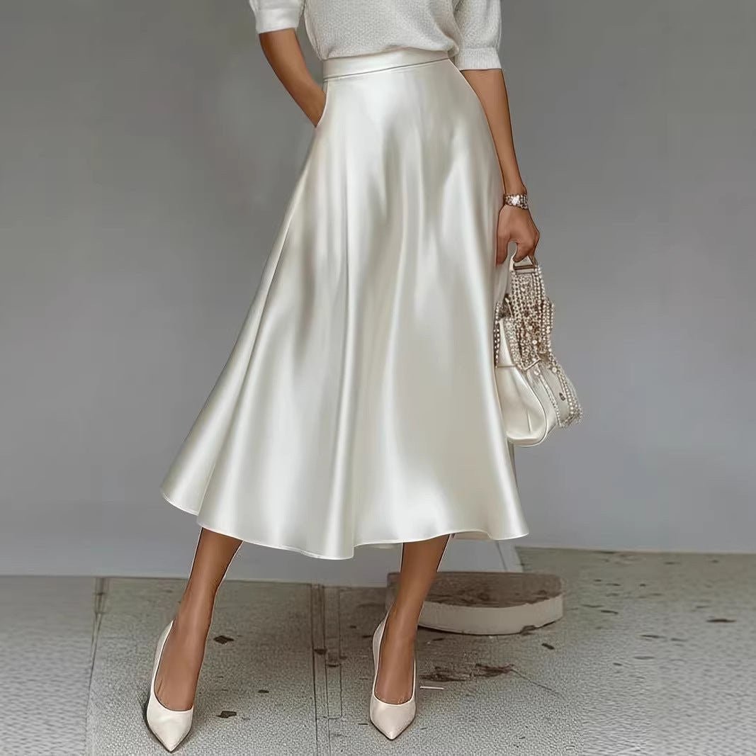 ZOFIA ATELIER white satin mid-length A-line skirt with pockets, paired with cream heels and a beaded clutch.